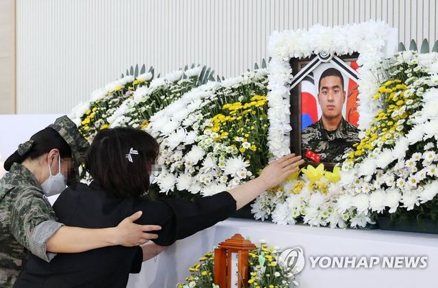 아들 사진 어루만지는 어머니