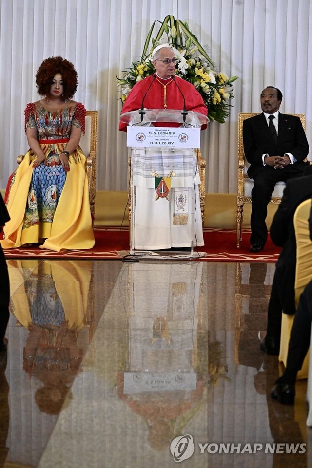 15일(현지시간) 카메룬 수도 야운데의 대통령궁에서 레오 14세 교황(가운데)이 폴 비야(오른쪽) 카메룬 대통령 부부 사이에 서서 발언하고 있다. [EPA=연합뉴스. 재판매 및 DB 금지]