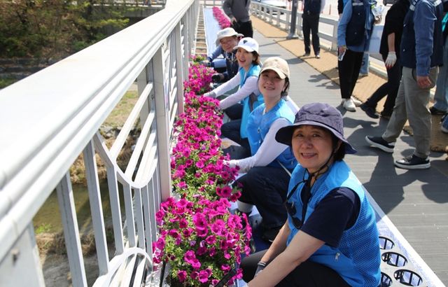 금토천변에 꽃 식재하는 이일화 배우와 임직원들