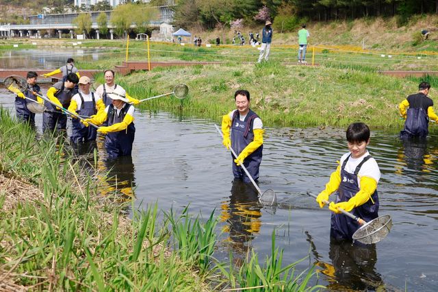 성남 수내 습지에서 부유물을 제거하는 HD건설기계 임직원들 