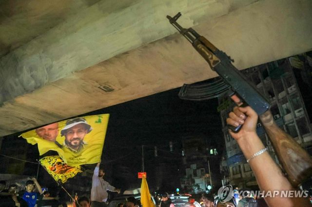 이스라엘과 휴전 협정을 자축하는 헤즈볼라 지지자들이 총을 들고 시위에 참여한 모습