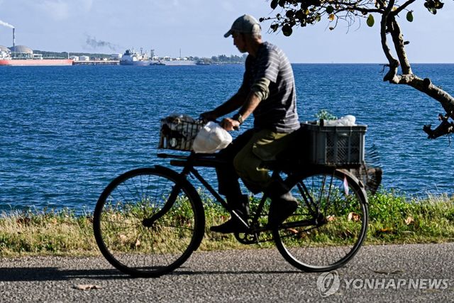 "신의 선물"이라 불리는 쿠바의 바다를 보며 자전거를 타는 남성