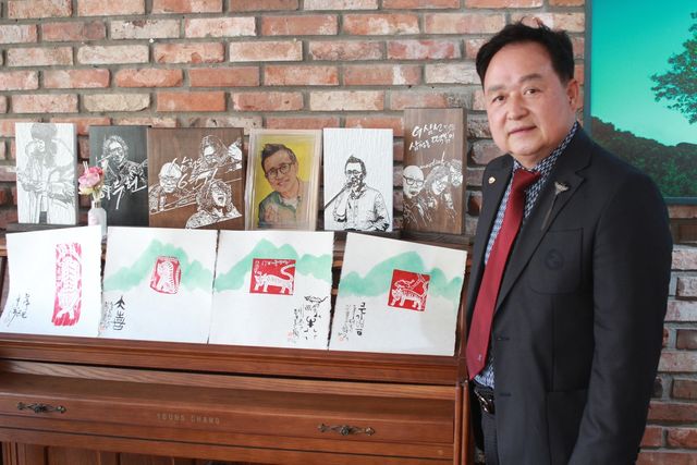 판화를 배경으로 포즈 취한 에드워드 손 대표