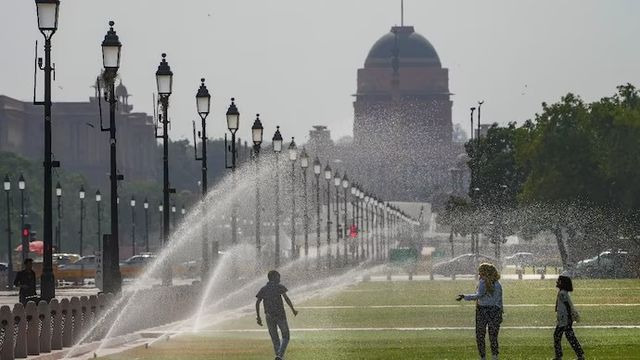 한 가족이 뉴델리 인디아게이트 부근서 더위를 식히는 모습