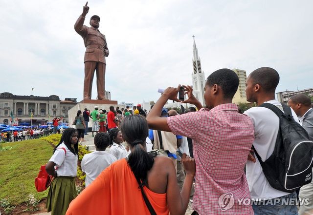 2011년 10월 19일 사모라 마셸 모잠비크 초대 대통령 25주기를 맞아 열린 동상 제막식에서 사진을 찍고 있는 주민들 [EPA 연합뉴스 자료사진. 재판매 및 DB 금지]