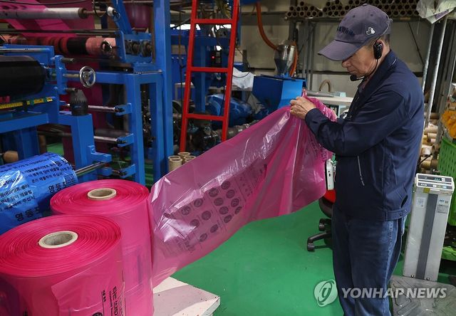 공장 관계자가 종량제봉투 품질을 확인하는 모습. [연합뉴스 자료사진]