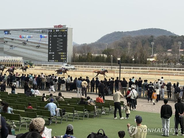 결승선 통과하는 경주마를 보기 위해 모여든 관람객들