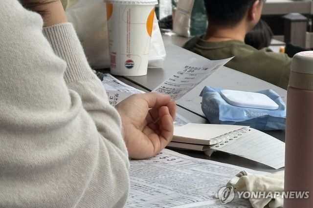 구매한 마권을 들고 있는 경마장 관람객