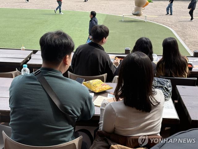 나무데크에 앉아 경마 관람하는 커플