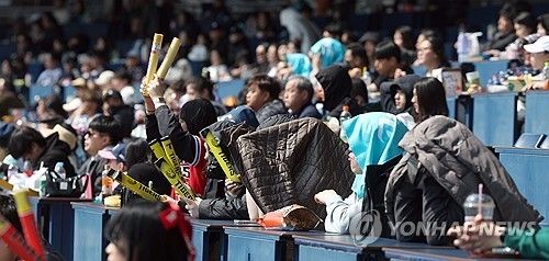 지난달 17일 경남 창원NC파크에서 열린 KIA 타이거즈와 NC 다이노스의 시범경기. 야구팬들이 겉옷으로 햇볕을 가린 채 응원하고 있다. [연합뉴스 자료사진]