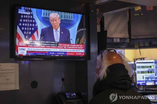 트럼프 기자회견을 지켜보는 뉴욕증권거래소의 트레이더