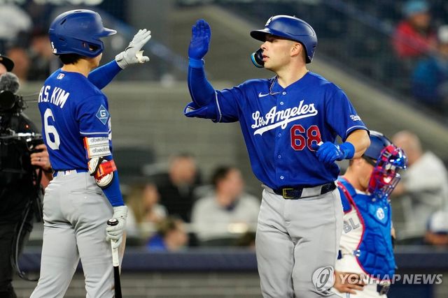 홈런을 치고 돌아온 러싱과 하이 파이브 하는 김혜성(왼쪽)