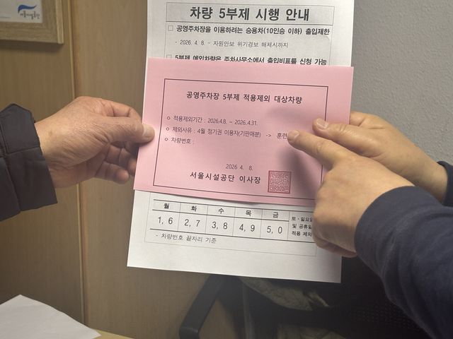 공영주차장에 '승용차 5부제'가 적용된 첫날인 8일 오전 중구 훈련원공원 공영주차장 주차관리실에서 정기권 이용자인 60대 남성 김모씨가 서울시설공단 관계자로부터 비표에 대한 설명을 듣고 있다. [촬영 조현영]