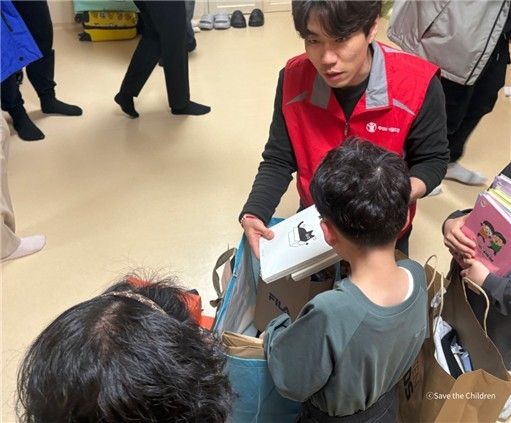 세이브더칠드런 직원이 산불로 대피한 아동에게 구호 물품을 전달하고 있다