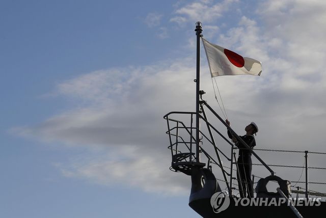 일본 가나가와현 요코스카(橫須賀)기지에서 자위대원이 뱃머리에 일장기를 다는 모습