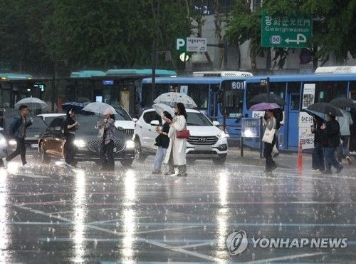 서울 광화문사거리에서 시민들이 우산을 쓴 채 횡단보도를 건너고 있다. [연합뉴스 자료사진]