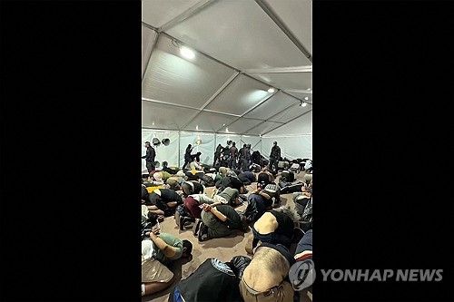이스라엘군 임시 수용소에서 두 손이 묶인 채 무릎을 꿇고 있는 구호선단 활동가들