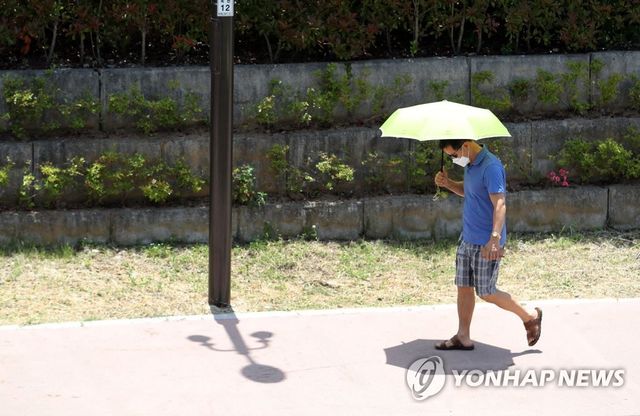 전남 순천시 옥천동 옥천교 인근에서 한 시민이 양산을 쓰고 걷고 있다
