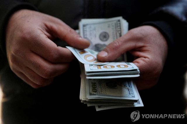 달러 지폐를 세는 테헤란 시민