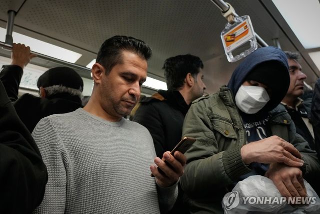스마트폰을 보는 테헤란 시민