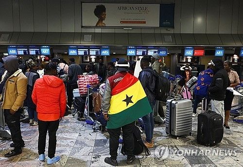 남아공 공항에서 출국 준비 중에 가나 국기를 두른 남성 