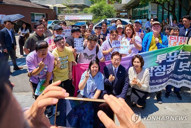 사전투표소 앞 장애인단체 관계자들 만난 이재명 대통령 부부