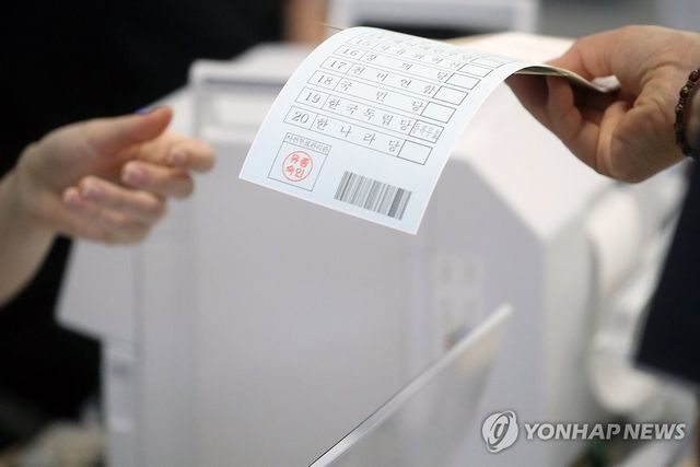 투표 용지 전달받는 유권자