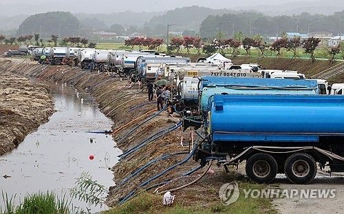 작년 9월 가뭄이 이어지는 강원 강릉시 한 하천에서 살수차들이 비가 내리는 가운데 운반급수를 위해 줄지어 취수하고 있다. [연합뉴스 자료사진]
