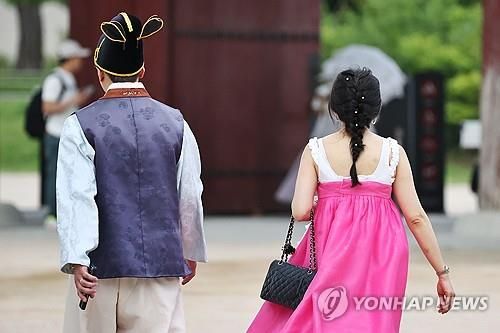 작년 7월 무더위 속에 한 관광객이 저고리를 벗은 채 경복궁을 구경하고 있다.