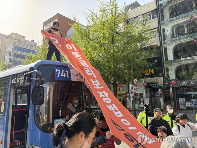 버스 위에 올라간 이동권 보장 촉구 시위 참가자
