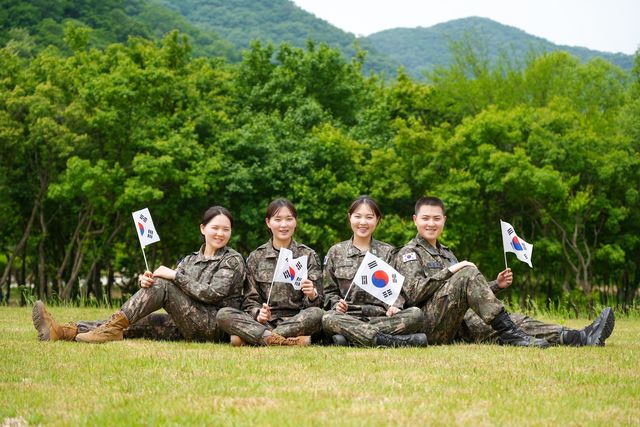 육ㆍ해ㆍ공군 부사관으로 복무 중인 김문정 중사, 김문소 중사, 김태희 중사, 김준원 하사(왼쪽부터) 4남매가 호국보훈의 달을 맞아 태극기를 들고 기념사진을 촬영하고 있다. [육군 제공]