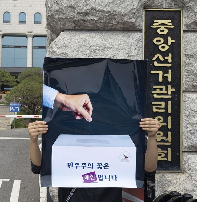 이제석씨가 펼쳐든 '민주주의의 꽃은 '매진'입니다' 포스터