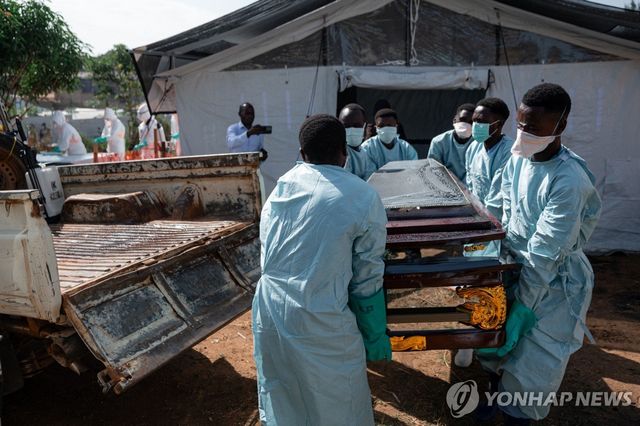 13일(현지시간) 콩고민주공화국 이투리주 부니아에서 적십자 자원봉사자들이 에볼라 사망자의 시신을 옮기고 있다.[AFP=연합뉴스. 재판매 및 DB 금지]