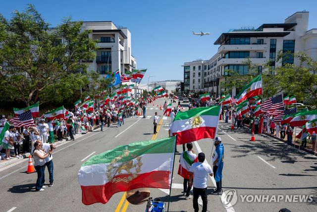 FIFA의 정책에 반대해 이란 혁명 이전 국기를 들고 행진하는 이란 응원단 