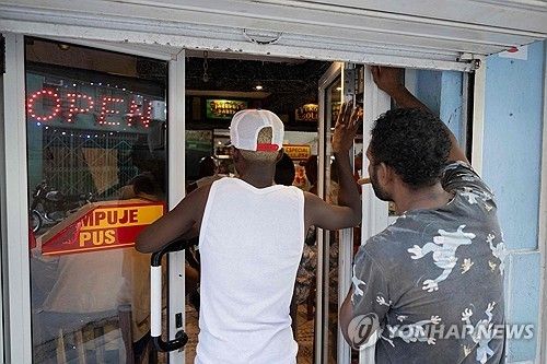 창문 틈으로 월드컵 경기를 보는 쿠바 서민들