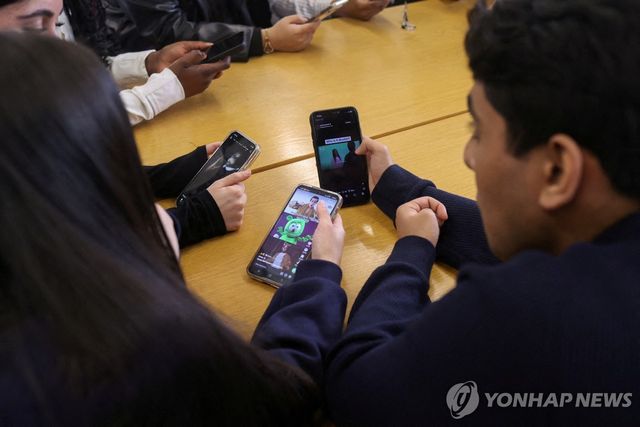휴대전화 보는 런던 청소년들