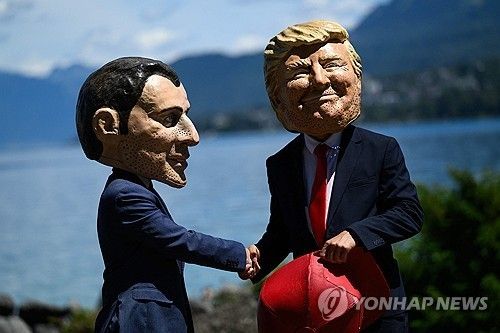 G7 반대 시위대가 마크롱, 트럼프 대통령 탈을 쓰고 풍자하는 모습