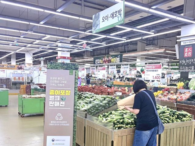 종이봉투에 오이를 담는 농협하나로마트 양재점 방문 고객