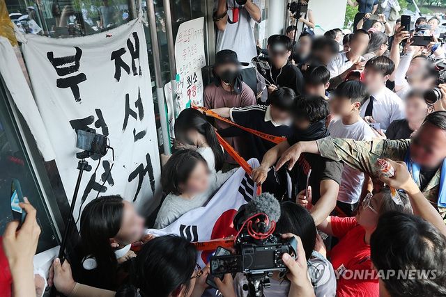 경기장 진입 막으려 문 꼭 쥔 시민