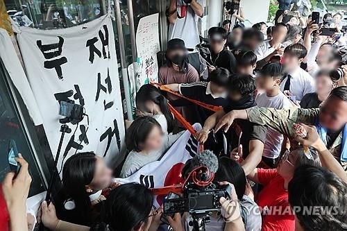경기장 진입 막으려 문 꼭 쥔 시민