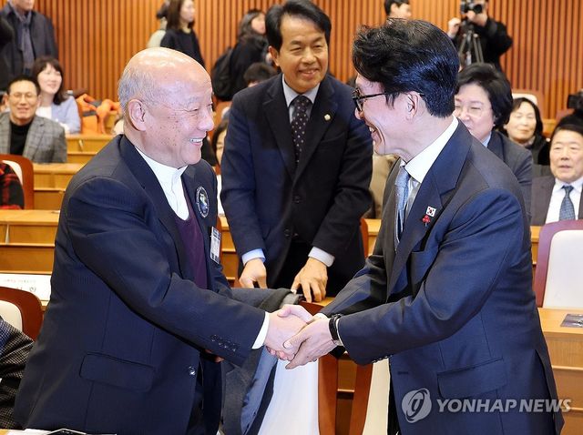 지난해 12월 악수하는 김민석 총리와 박석운 위원장