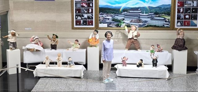 마지막 전시회에서 작품들을 배경으로 기념촬영한 김미숙 작가