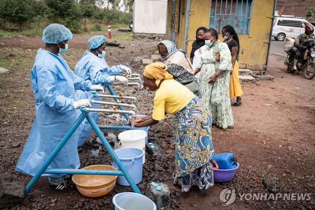 지난달 27일(현지시간) 콩고민주공화국 카냐루치냐 지역 주민들이 에볼라 방역 검문소에서 손을 씻고 있다. [EPA 연합뉴스 자료사진. 재판매 및 DB 금지]