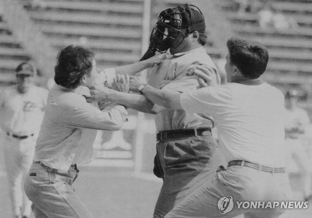 1994년 6월 11일 태평양-LG 경기 도중 심판 판정에 불만을 품은 관중 한명이 그라운드로 뛰어들어 심판의 멱살을 잡고 행패를 부린 모습