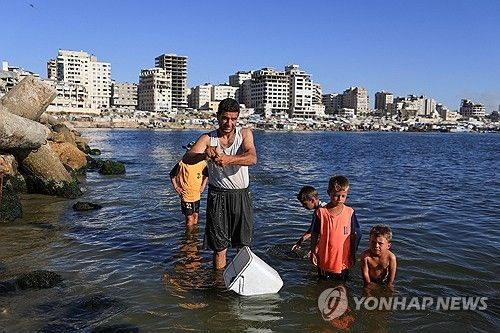 더러운 바닷물로 빨래하고 목욕하는 피란민 가족