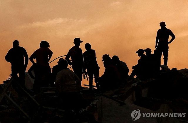 25일(현지시간) 베네수엘라 지진 현장 건물 잔해 위의 사람들 