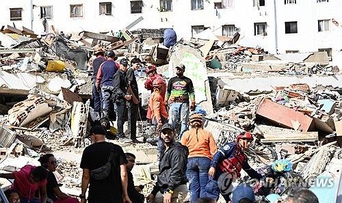 26일(현지시간) 베네수엘라 리과이라주에서 지난 24일 강진에 무너진 건물 잔해를 구조대와 봉사자들이 수색하고 있다. [AFP=연합뉴스]