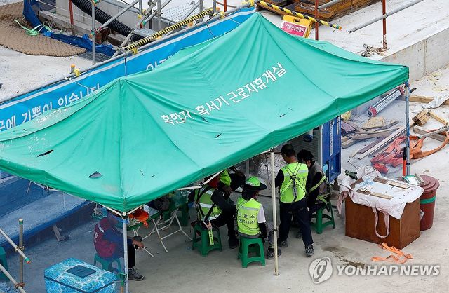 휴식 취하는 건설현장 작업자들