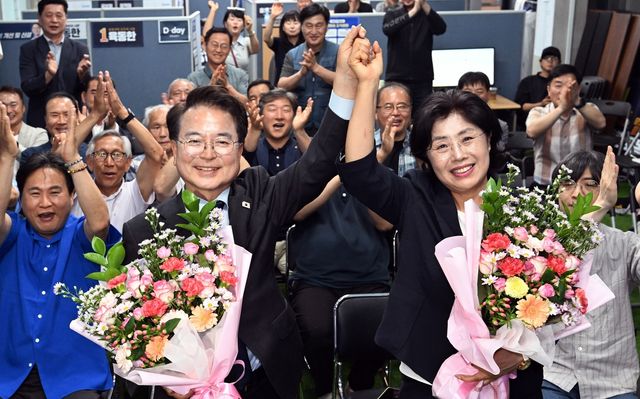 육동한 당선인(왼쪽)이 아내와 함께 지지자들에게 손을 들어 인사하고 있다