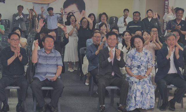 방송3사 출구조사 결과를 보며 박수 치는 윤건영(가운데) 당선인